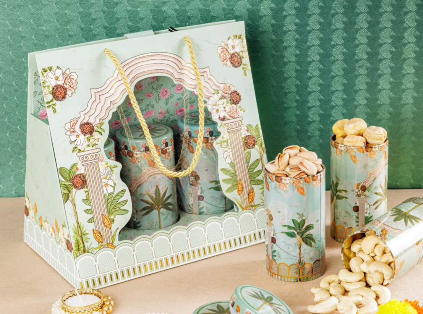 Product shoot of luxury floral-themed canisters and matching gift bags for premium nuts and snacks.