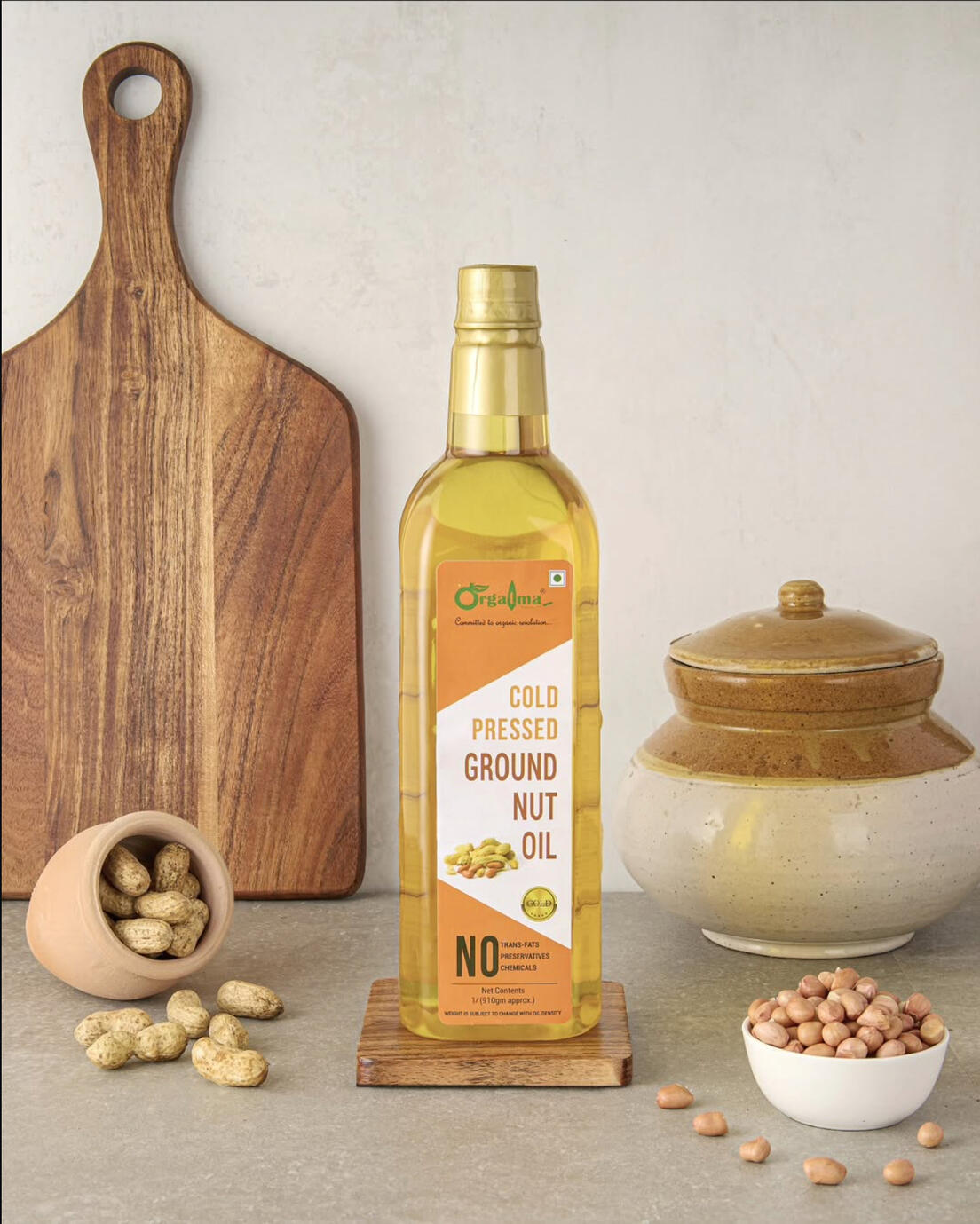 Gowri Cold Pressed Ground Nut Oil bottle with raw peanuts on rustic wooden board.